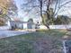 Large backyard with patio, tree, and white privacy fence at 2711 Cowles Rd, Charlotte, NC 28208