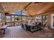 Relaxing screened porch overlooking the water with wicker furniture at 379 Alberta Dr, Norwood, NC 28128