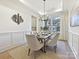 Formal dining room with hardwood floors, chandelier, and built-in wall paneling at 3837 Bon Rea Dr, Charlotte, NC 28226