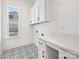 Bright laundry room with white cabinets, marble countertop, and patterned tile floor at 3837 Bon Rea Dr, Charlotte, NC 28226