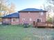 Backyard view of a two-story brick home with a deck, trampoline, and grassy area at 130 Devine St, Stanley, NC 28164