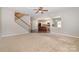 Living room with carpet, ceiling fan, and kitchen view at 15019 Ockeechobee Ct, Mint Hill, NC 28227