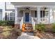 Inviting front porch with blue door, brick steps, and white railings at 19818 Wooden Tee Dr, Davidson, NC 28036