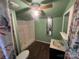 Small bathroom with shower/tub combo, toilet, and vanity, light green walls and wood-look flooring at 3217 Howe Dairy Rd, Gastonia, NC 28056