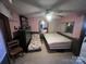 Small bedroom with a bed, floral couch, and TV. Pink walls, wood-look flooring at 3217 Howe Dairy Rd, Gastonia, NC 28056