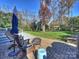 Large backyard with patio, fire pit, and lush green grass at 5227 Chedworth Dr, Charlotte, NC 28210