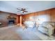 Living room with wood paneling, fireplace, and carpeted floor at 1120 Jug Broome Rd, Monroe, NC 28112