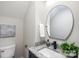Modern bathroom with a navy blue vanity and a large round mirror at 310 Town St, Landis, NC 28088