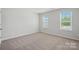 Well-lit bedroom with neutral walls, carpet, and two large windows at 8216 Stonemere Ln, Charlotte, NC 28215