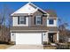 Two-story house with gray and brown siding, white garage door, and landscaping at 15533 Capps Rd, Charlotte, NC 28278