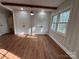 Dining room with white walls, wood-look floors, windows, and white doors at 1327 Marble St, Charlotte, NC 28208