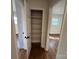 Hallway linen closet with built-in shelving, hardwood floors, and doorways to adjacent rooms at 1327 Marble St, Charlotte, NC 28208