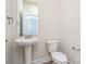 Simple bathroom with pedestal sink, toilet, and a mirror at 203 Susannah St, Troutman, NC 28166