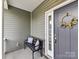 Small front porch with a bench and pillows, offering a relaxing spot at 225 Jaida Ln, Oakboro, NC 28129