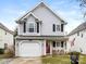 Two-story house with gray siding, a red door, and a two-car garage at 2711 Rozzelles Landing Dr, Charlotte, NC 28214