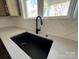 Modern kitchen features a black farmhouse sink and herringbone tile backsplash at 1875 Rock Hill Church Rd # 4, Matthews, NC 28104