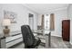 Home office with a glass desk, window, and built-in shelving at 1902 W Sugar Creek Rd, Charlotte, NC 28262