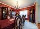 Elegant dining room with rich walls, a formal table setting, and a stunning chandelier at 230 Primrose Dr, Stony Point, NC 28678