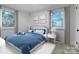 Virtually staged bedroom with blue bedding and white nightstand at 1908 Dickens Ave, Charlotte, NC 28208