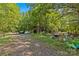 Gravel parking area with various debris and outbuildings at 5621 Mount Olive Church Rd, Charlotte, NC 28278