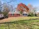 Brick ranch home with a large tree and landscaped yard at 1511 Anthony Dr, Gastonia, NC 28052