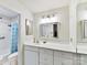 Clean bathroom with vanity, mirror and light blue shower curtain at 1708 Roxborough Rd # E, Charlotte, NC 28211