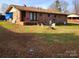 Backyard view of a brick ranch-style house with a small patio and fire pit at 2040 Ne 25Th St Dr, Hickory, NC 28601