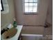 Small bathroom with a sink, tub and a window at 2804 Westview St, Gastonia, NC 28056