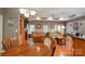 Open-concept dining area adjacent to the living room with a view of the stone fireplace at 412 Cornerstone Dr, Taylorsville, NC 28681