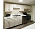 White kitchen cabinets, stainless steel appliances, and wood-like floors at 9530 Shannon Green Dr # K, Charlotte, NC 28213