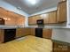 Modern kitchen with light wood cabinets, black appliances, and ample counter space at 104 Kensington St, Mooresville, NC 28117