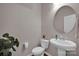 Clean powder room with pedestal sink, toilet, and round mirror at 132 Cherry Bark Dr, Mooresville, NC 28117