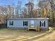 Gray mobile home with black shutters and a wood deck, sitting on a grassy lot at 46 Kidd And Brown Rd, Hiddenite, NC 28636