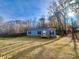 Gray mobile home with black shutters and wood deck, nestled in a wooded area at 46 Kidd And Brown Rd, Hiddenite, NC 28636