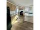 Modern kitchen with light wood cabinets, island, and black appliances at 46 Kidd And Brown Rd, Hiddenite, NC 28636