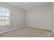 Spacious carpeted bedroom with large window and neutral wall colors at 641 Woodington Ln, Charlotte, NC 28214