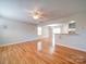 Open living room with hardwood floors, ceiling fan, and view of the kitchen at 11116 Northwoods Forest Dr, Charlotte, NC 28214