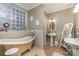 Bathroom with a claw-foot tub, dual sinks, and tiled walls at 318 N Elm St, Marshville, NC 28103