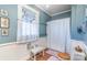 Blue and white bathroom with a shower, toilet, and window at 318 N Elm St, Marshville, NC 28103