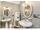 Bathroom with dual pedestal sinks, round mirrors, and soft lighting at 318 N Elm St, Marshville, NC 28103