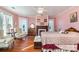 Pink bedroom with fireplace, hardwood floors, and cozy seating area at 318 N Elm St, Marshville, NC 28103