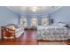 Bright bedroom with large windows, wooden bedframe, and hardwood floor at 318 N Elm St, Marshville, NC 28103