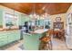 Bright kitchen with light green cabinetry, island with cooktop, and dining area at 318 N Elm St, Marshville, NC 28103