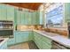 Kitchen features light green cabinetry, stainless steel appliances, and large window at 318 N Elm St, Marshville, NC 28103