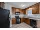 Bright kitchen with dark wood cabinets, black appliances, and tile flooring at 501 Mt Sinai Church Rd # 18, Shelby, NC 28152