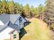 Modern farmhouse exterior with stone accents, spacious backyard, and detached shed at 5164 Green Rd, Stanley, NC 28164
