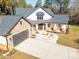 Modern farmhouse with stone and white exterior, circular driveway, and landscaping at 5164 Green Rd, Stanley, NC 28164