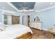 Main bedroom with a barn door, tray ceiling, and large dresser at 5164 Green Rd, Stanley, NC 28164