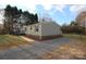 Side view of tan mobile home with new deck and gravel driveway at 5811 Monarch Pass, Claremont, NC 28610