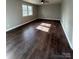 Living room with dark laminate floors and large window at 129 Mapleleaf Rd, Statesville, NC 28625